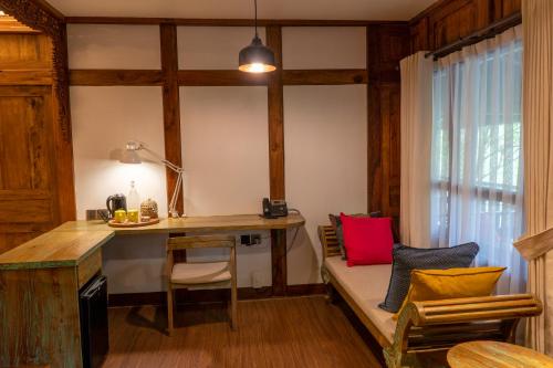 a room with a desk and a bench with a table at Tira Vilagna Suites & Spa in Kintamani