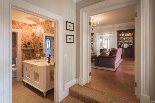 a hallway of a home with a sink and a living room at Lombard Villa in Plettenberg Bay