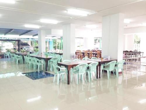 a room with tables and chairs in a library at Eden Garden Resort in Chiang Mai