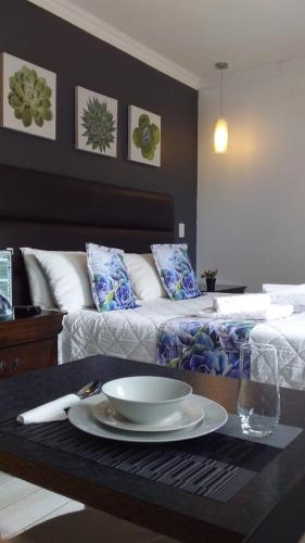a living room with a table with a plate of food at VillaVin at 25 Vigne in Port Elizabeth