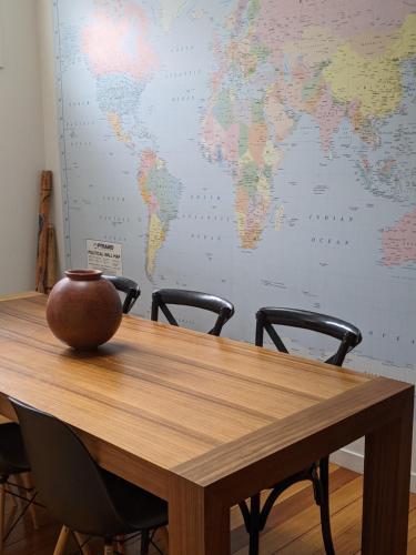a wooden table with two chairs and a world map on the wall at The Old Federal Coffee Palace in Launceston