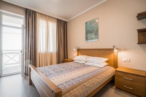 a bedroom with a bed and a large window at Villa Aquamarin Buhaz in Zatoka