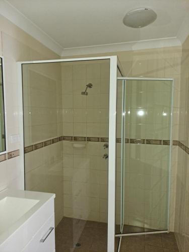 a bathroom with a glass shower and a sink at Albion Hotel in Kalgoorlie