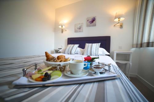 Hotel Restaurant Le Lion d'Or في سانت-هيلير-دو-هاركويت: صينية طعام تجلس فوق السرير