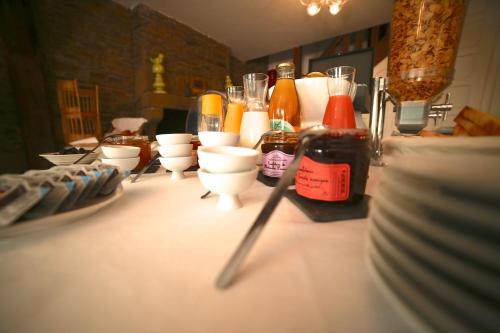 Hotel Restaurant Le Lion d'Or في سانت-هيلير-دو-هاركويت: طاولة عليها مجموعة من الأكواب والزجاجات