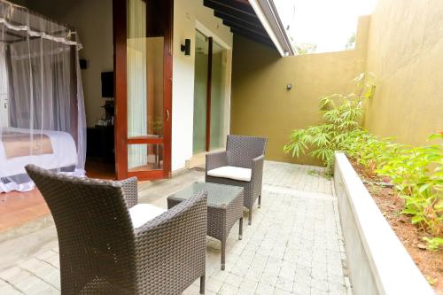 a patio with wicker chairs and a table at Swanee Grand in Negombo