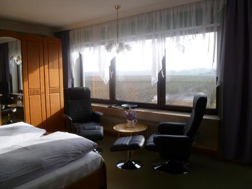 sypialnia z łóżkiem, 2 krzesłami i oknem w obiekcie Haus Lissi w mieście Bad Füssing