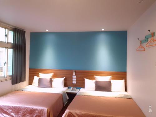 基隆的住宿－永豐旅社，一间设有两张床和蓝色墙壁的客房