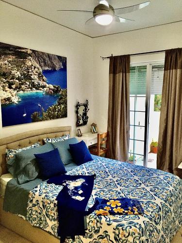 a bedroom with a bed with a painting on the wall at Gallery Apartments in Lixouri