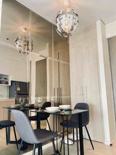 a dining room with a table and chairs and chandeliers at Veranda Residence Pattaya By Fon in Na Jomtien