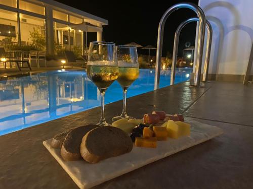 a plate of cheese and two glasses of wine at Nama Retreat in Pastida