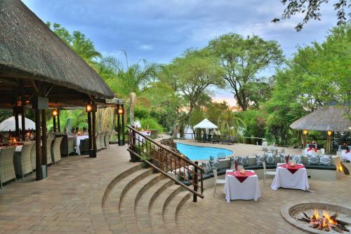 a resort with a pool and tables and chairs at Cresta Mowana Safari Resort & Spa in Kasane