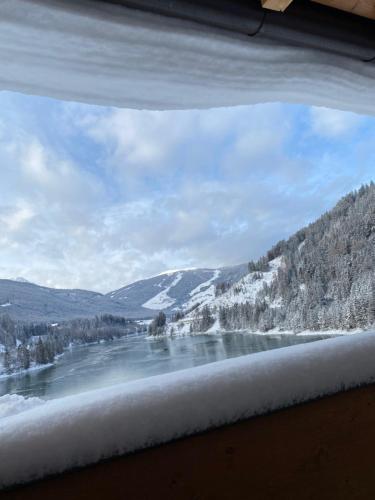 a view of a river from a window with snow at Hotel Seehof in Monguelfo