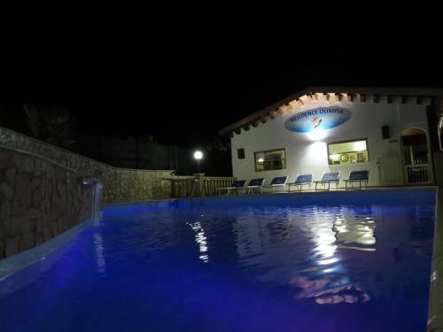 una piscina di fronte a una casa di notte di Residence Olimpia a Peschici