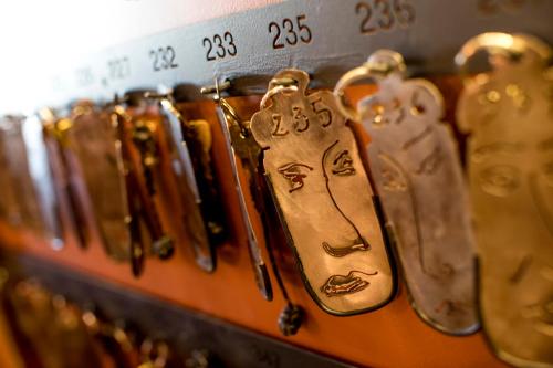 a row of gold key chains on a shelf at Le Grand Hotel in Sète