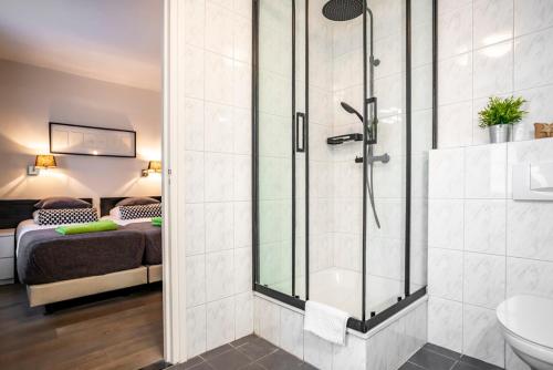 łazienka z prysznicem, toaletą i łóżkiem w obiekcie Saga and More B&B Brasserie w mieście Berg en Terblijt