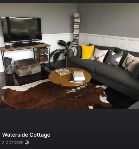a living room with a couch and a coffee table at Waterside Cottage in Daylesford