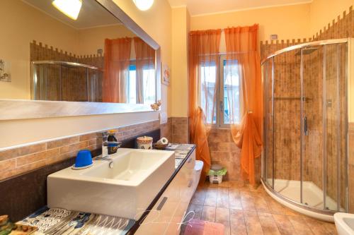 ein Bad mit einem Waschbecken und einer Dusche in der Unterkunft Tea Versilia - Forte dei Marmi in Forte dei Marmi