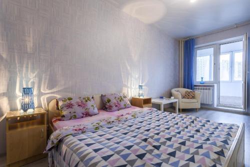 a bedroom with a large bed and a large window at Apartment on Glukharskaya near MIBS in Saint Petersburg