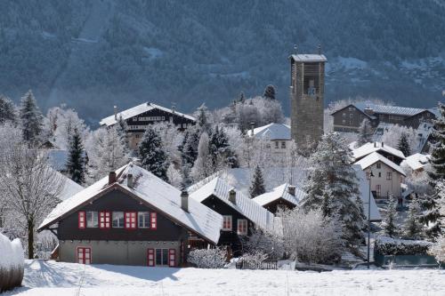 a snow covered village with a building and a tower at CHALET Les Chouchous in Passy