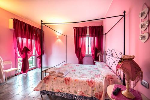 ein rosafarbenes Schlafzimmer mit einem Bett mit Metallrahmen in der Unterkunft Tea Versilia - Forte dei Marmi in Forte dei Marmi