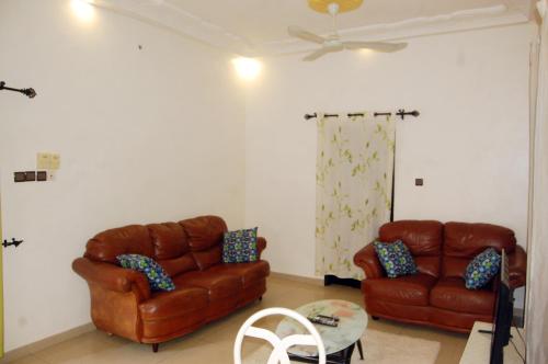 a living room with two leather couches and a table at Résidences ASKÉ in Abomey-Calavi
