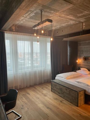a bedroom with a large bed and a large window at LOFTSTYLE Hotel Hannover, Best Western Signature Collection in Hannover