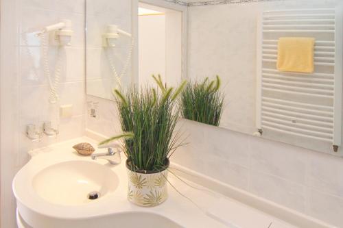 uma casa de banho com um lavatório, um WC e um espelho. em Seehotel ZUR MÜNZ em Meersburg