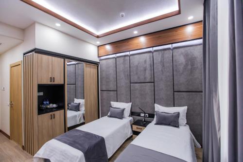 a bedroom with two beds and a wall at Art Deluxe Hotel in Tashkent