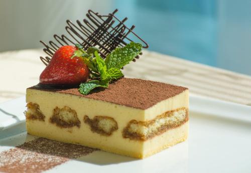 a piece of cake with a strawberry on top at Holiday Inn Muscat AlSeeb by IHG in Muscat