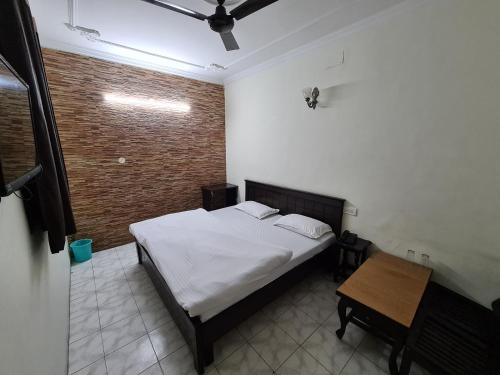 a bedroom with a bed and a wooden table at Hotel Victoria in Chandīgarh