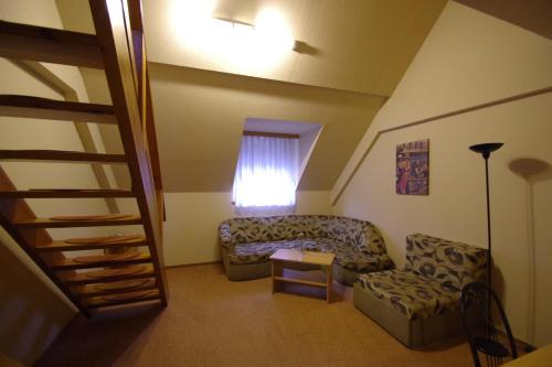 a living room with a couch and a chair at Hotel Vadászkürt Superior in Székesfehérvár
