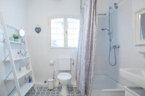 a white bathroom with a toilet and a shower at Altes Kontorhaus Steuerbord in Husum