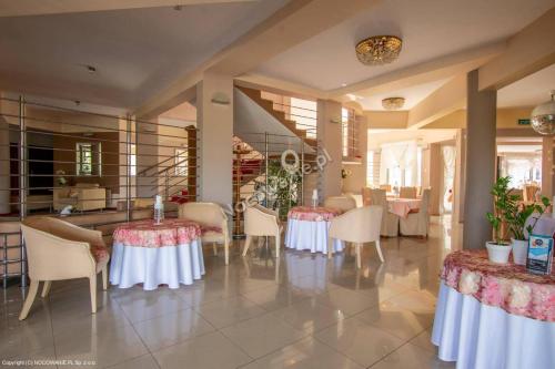 a dining room with tables and chairs in a room at Willa Rawia 2 in Rewal