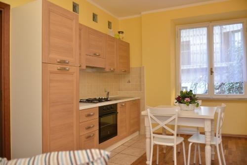 uma cozinha com armários de madeira e uma mesa com cadeiras em RIETINN em Rieti
