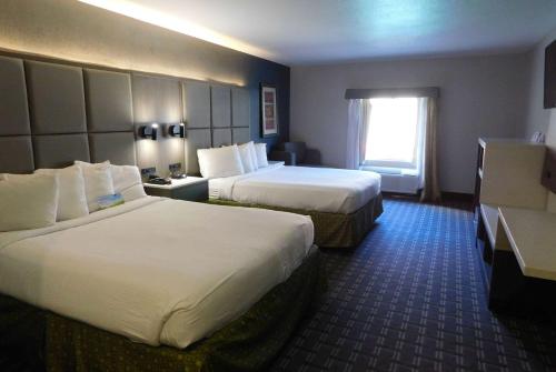 a hotel room with two beds and a window at Days Inn & Suites by Wyndham Downtown Gatlinburg Parkway in Gatlinburg