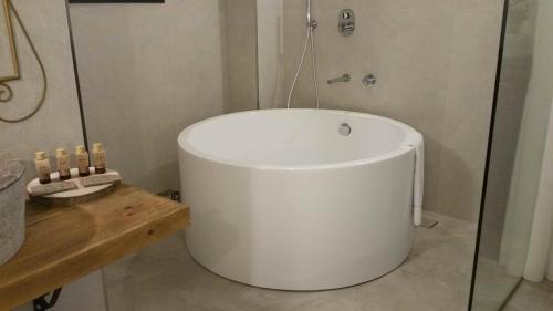 a white tub in a bathroom with a shower at Murallas de Jayrán Hotel Boutique in Almería
