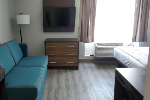 a hotel room with a couch and a tv at Hawthorn Extended Stay by Wyndham Panama City Beach in Panama City Beach