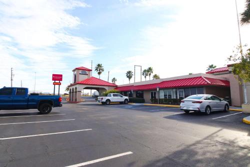 a parking lot with cars parked in front of a gas station at Ramada by Wyndham Davenport Orlando South in Davenport