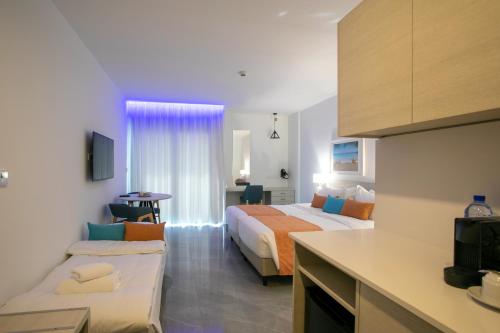 a hotel room with two beds and a kitchen at Best Western Plus Larco Hotel in Larnaka