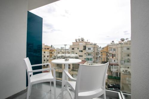 a white table and chairs on a balcony with a view at Best Western Plus Larco Hotel in Larnaka