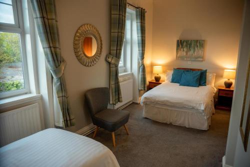 ノーサンプトンにあるThe Walnut Tree Innのベッドルーム1室(ベッド2台、椅子、鏡付)