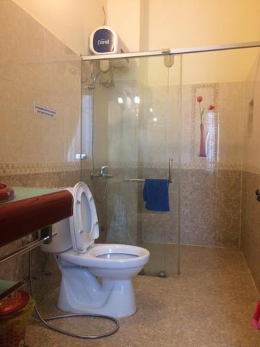 a bathroom with a toilet and a glass shower at Thien Phu Guesthouse Dalat in Da Lat