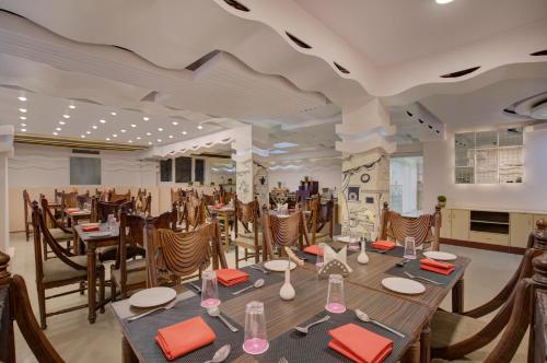 uma sala de jantar com mesa e cadeiras em Mount Conifer Suites & Spa em Darjeeling