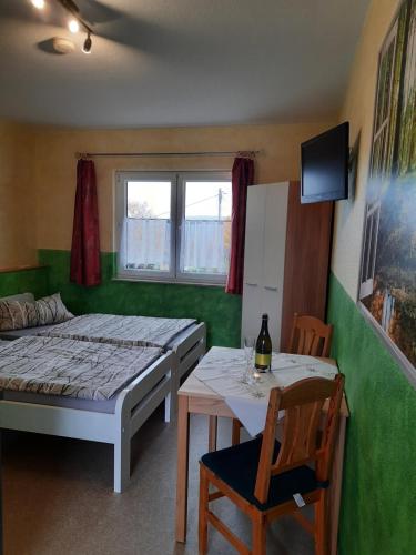 a bedroom with a bed and a table with a chair at Haus Panoramablick Familie Loos in Wasungen