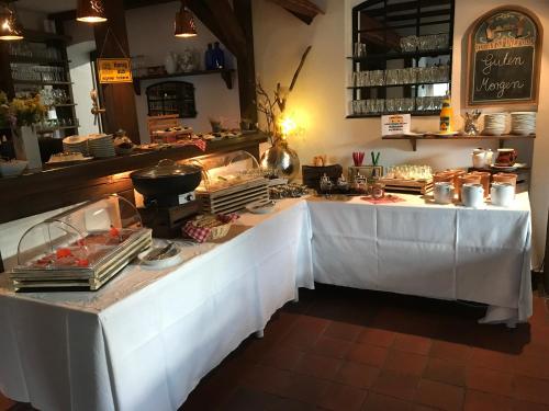 a buffet table with white clothed tables in a restaurant at Landhotel Belitz Garni in Küsten
