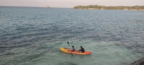 two people are sitting on a kayak in the water at Rosario EcoHotel in Isla Grande
