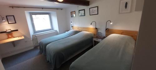 a room with three beds and a window at La Fermette Blanche in Nadrin