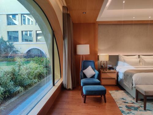 1 dormitorio con 1 cama, 1 silla y 1 ventana en Belvedere Golf & Country Club, en Adalaj