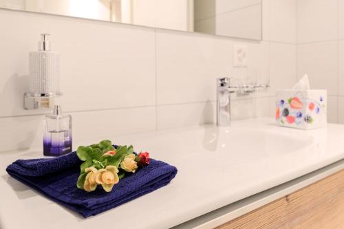 a bathroom sink with a blue towel with flowers on it at Jolimont Apartments in Zermatt